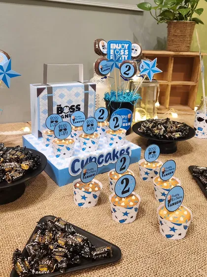 The sweet buffet for a Boss Baby party, featuring themed cupcakes, chocolates, and other treats.