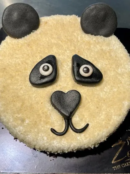 A simple yet charming panda face cake. This sculpted design uses a crumb-coat texture for fur and fondant details for the eyes, nose, and ears, creating a cute and minimalist animal cake.