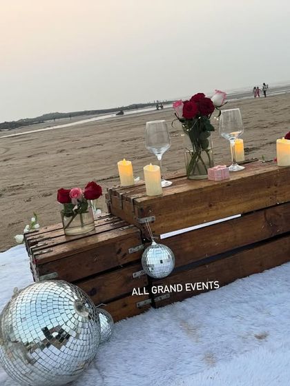 A close-up of the rustic crate table, adorned with red roses, wine glasses, and candles. It’s these small details that make our proposal decorations feel personal and special.
