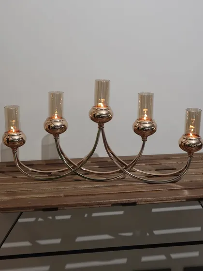 The Vesper Quintet 5-tube candelabra in its full glory. Its graceful, intersecting arms and rose-gold finish create a captivating centerpiece for any dining table or console.
