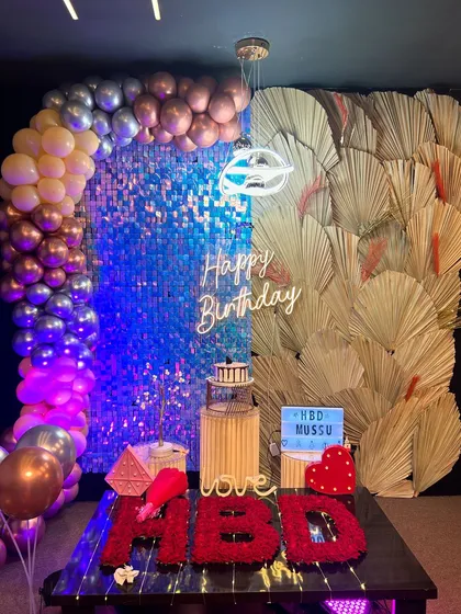 A stunning birthday setup featuring a blue sequin wall, a balloon arch in metallic tones, and dried palm leaves for a modern, chic vibe. This is how you celebrate 25 in style.