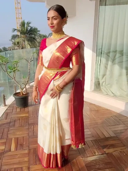 This bride opted for broader pleats for her wedding look, creating a bold and beautiful silhouette. Her white and red Kanjeevaram is a picture of classic South Indian bridal style.