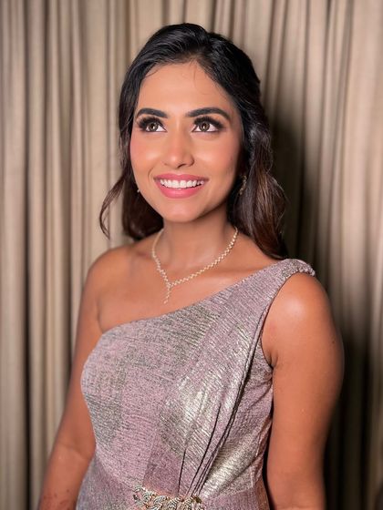 This candid, upward glance captures the beautiful radiance of the makeup. The highlighter catches the light perfectly, giving her that fresh, golden glow that looks amazing both in person and in wedding photos.