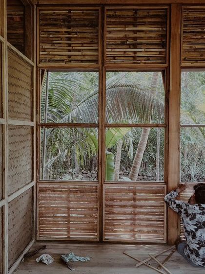 An artisan finishing the window details of the prefab cottage, a process that requires precision and skill.