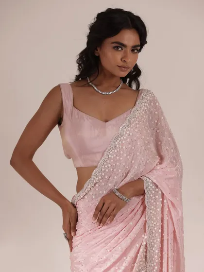 This light pink sequined saree is all about feminine grace. Paired with a simple diamond necklace and bracelet, it's an understated yet glamorous option for a wedding guest.
