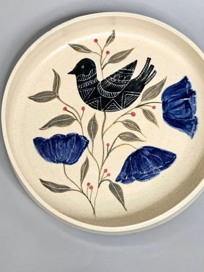 Another view of a sold bird and floral plate. The combination of sgraffito on the bird and the fluid painting of the flowers creates a beautiful texture and depth.