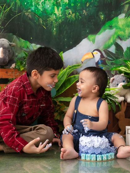 Brothers sharing a cake smash. Capturing sibling interactions during milestone sessions adds another layer of storytelling and love.
