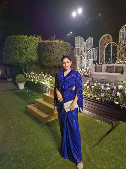 A client radiates pure elegance in this breathtaking active blue fully embellished cape set, a perfect blend of grace, glamour, and statement style.