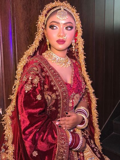 This maroon velvet lehenga features a beautiful doli motif embroidered on the skirt. It's a very traditional and royal piece, perfect for making a grand entrance.