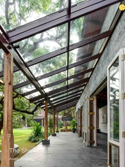 The Shell in Alibag, a pavilion designed to celebrate design. The glass roof of the verandah allows for an uninterrupted connection with the sky and surrounding trees, making it a perfect space for creative thought.