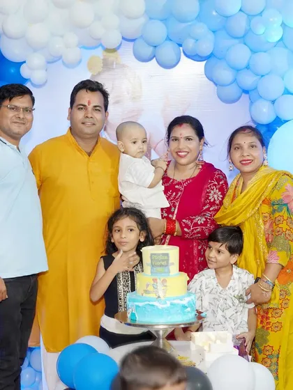 A large family group gathers for a photo around the birthday cake. We are experienced in organizing and capturing great shots of extended families at events.
