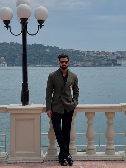 The full look of our olive green double-breasted blazer, showcasing its versatility when paired with simple black trousers.