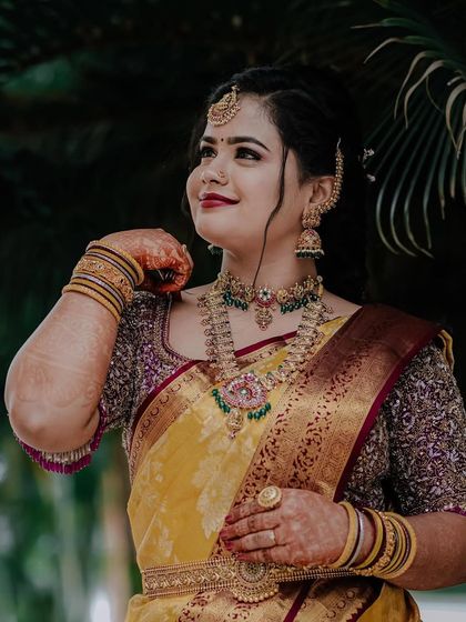 A confident and happy pose. Inchara's full jewellery set shines, showing how our pieces can make any special day even more memorable.