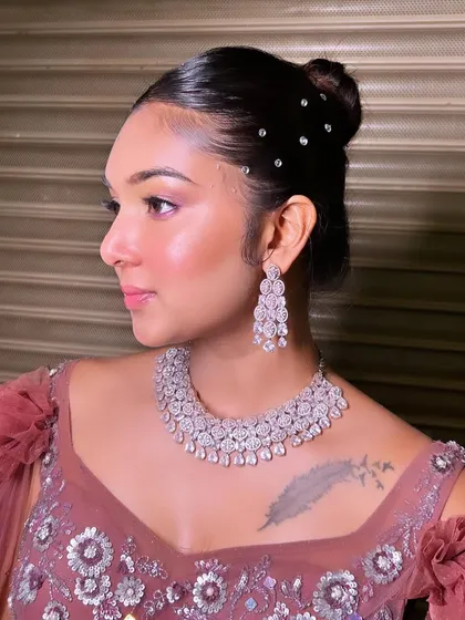A sleek and modern bun, dotted with crystals for a touch of sparkle. This hairstyle is perfect for a glamorous reception or cocktail party look.