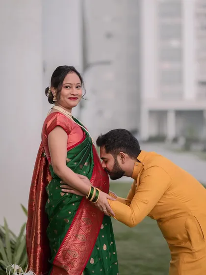A classic and tender maternity portrait of a husband-to-be kissing his wife's baby bump. This outdoor pregnancy photoshoot in Bangalore captures the couple's love and excitement in a natural setting.