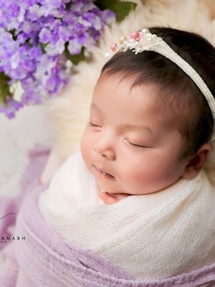 A serene portrait of the same baby, looking peaceful and content.