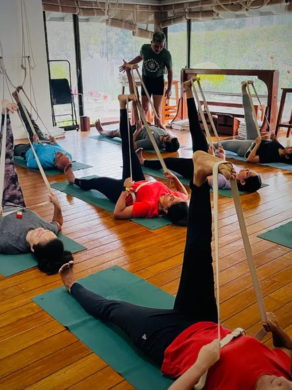 A glimpse into our practice, where students use belts for leg stretches. This prop is essential for achieving deeper, safer stretches and is a hallmark of the Iyengar method.