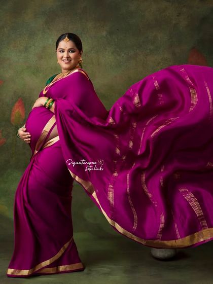 The flowing magenta saree adds a dramatic and artistic flair to this studio portrait.