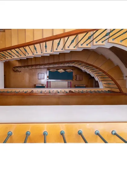 A view from the top of the winding staircase reveals the home's vertical connectivity and the beautiful curvature of its design, drawing the eye downwards through multiple levels.