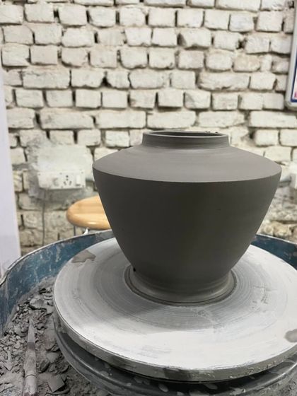 A freshly thrown pot with a strong, angular shoulder, still on the pottery wheel. I love exploring different profiles and shapes, from soft curves to sharp, defined edges.