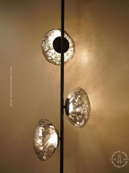 This vertical fixture features textured, moon-like chrome orbs attached to a central black rod. It's a striking, artistic piece that works well in corners or narrow spaces, adding a touch of celestial-inspired modernism.