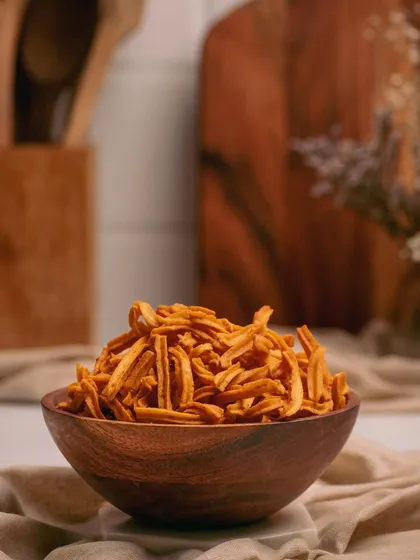 A wooden bowl filled with crispy, savory sticks. The focus on the texture and the warm, earthy tones of the shot give it a wholesome and appetizing feel.