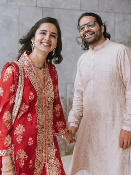 A lovely portrait of the couple holding hands, smiling warmly at the camera. Their traditional attire and genuine happiness make this a beautiful memory.