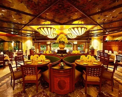 I believe a great meal deserves a fantastic vibe. My restaurant's ambiance, with its intricate ceiling, classic booth seating, and warm lighting, is designed to make every moment feel like a special occasion.