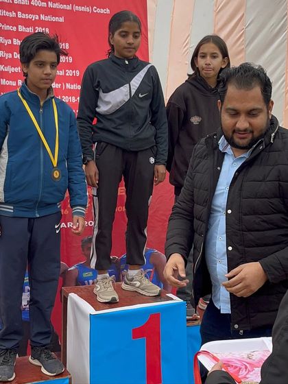 A young athlete on the podium. We instill a winning mentality from the very beginning of their journey with us.