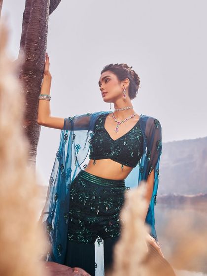 A breathtaking finale from the Jalsaa-e-Bahaar collection, this teal lehenga with a dramatic cape is where colour, culture, and couture collide.