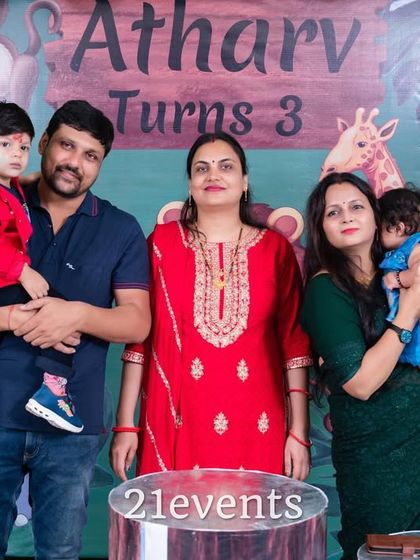A happy family photo in front of their jungle party decor.