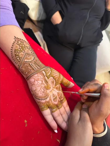 Here I am, focused on creating a delicate peacock design. Each piece is a collaboration between my art and the client's vision.