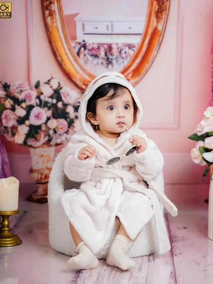 A different kind of princess. This little one is chilling in her robe and shades, looking like a tiny superstar in a glamorous pink room.
