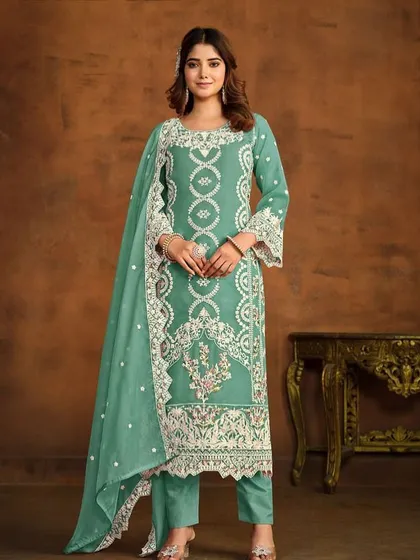 A light green organza suit with beautiful white thread embroidery. The bell sleeves and delicate lacework add a touch of vintage charm.