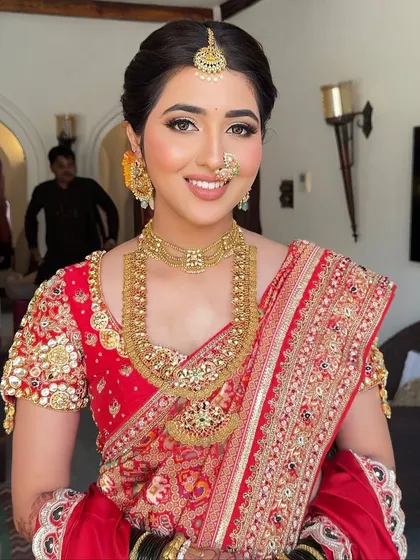 A close-up of our bride Diksha, looking graceful in her traditional red attire. The look features a sharp wing liner and a soft, radiant base that enhances her natural beauty.