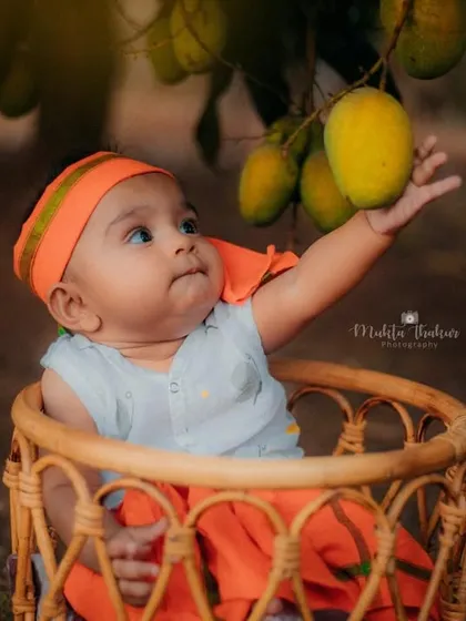 Sometimes the best studio is the great outdoors. For this unique six-month milestone session, we went to a mango farm to capture this little one's curiosity among the sweet, hanging fruits.