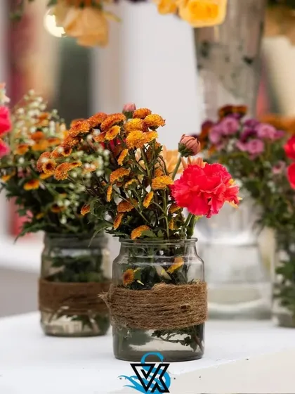 Another example of our rustic-chic centerpieces. A simple glass jar with a jute wrap holds a bunch of colorful chrysanthemums, perfect for a casual daytime event.