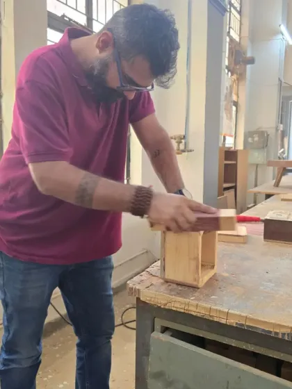 A student carefully sands the edges of the box by hand. This meticulous finishing work is what elevates a project from good to great, ensuring all surfaces are smooth and all joints are flush.