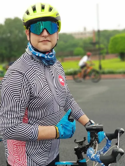 A stylish cyclist posing with his bike. Our members have great taste in both gear and fashion.