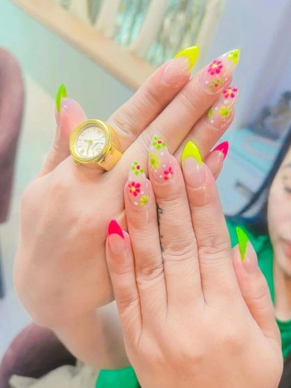 A vibrant and fun set with neon pink and green French tips, accented with hand-painted floral dots. This look is perfect for a summer holiday.
