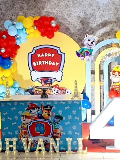 A colorful Paw Patrol themed birthday party for a 4th birthday, with character cutouts and a vibrant balloon arrangement.