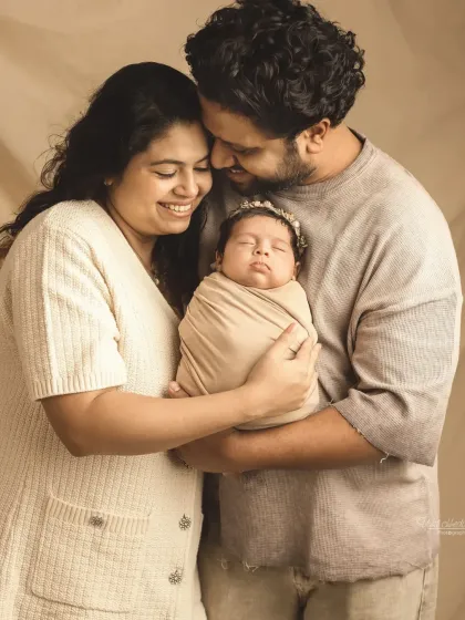 A beautiful family portrait with the newborn princess wearing a delicate crown.