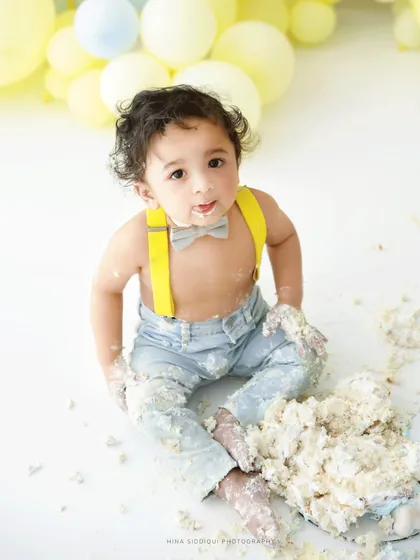 What is a first birthday without a little bit of cake? This moment from a 'You Are My Sunshine' themed cake smash session is pure joy. I love capturing their curious expressions as they explore the sweet, messy fun.
