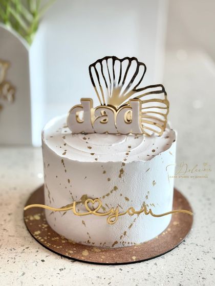 An elegant mini cake for Father's Day, featuring a white and gold design with a "Dad, I love you" topper.
