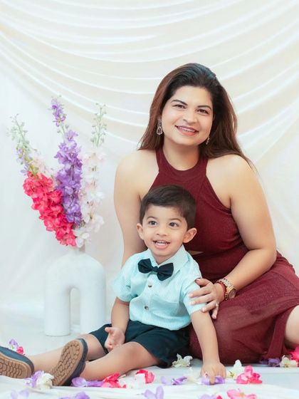A happy mother and son sitting together amongst flowers in our studio. A perfect portrait to celebrate their special bond.