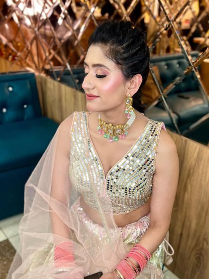 A soft and pretty look for a daytime event. The client is wearing a silver mirror-work lehenga, and we created a pink-toned makeup look to match.