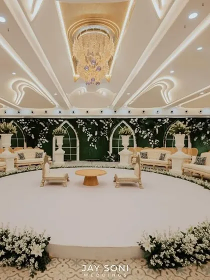 A straight-on view of the circular indoor mandap, emphasizing its symmetry and the clean, sophisticated aesthetic created by the white color palette and lush florals.