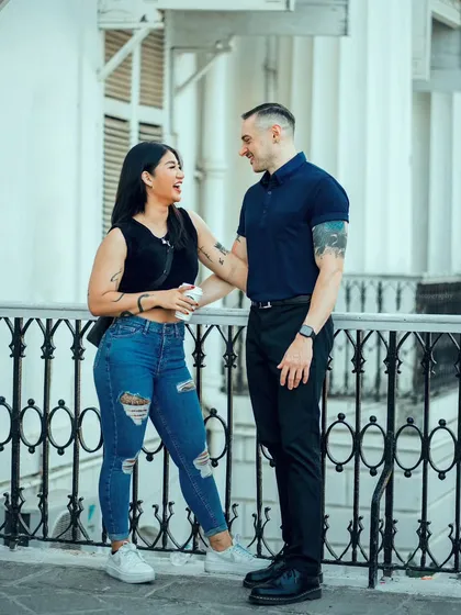 Sharing a laugh on a balcony overlooking the city. This photo captures a genuine moment of connection and happiness.