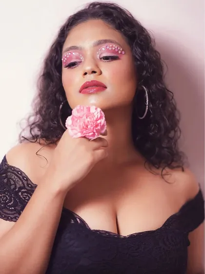 A portrait showcasing the dreamy quality of the pink pearl eye makeup. The soft lighting and flower prop enhance the romantic and artistic feel of the look.