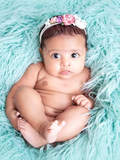 Those big, beautiful eyes are looking right at the camera. A simple portrait on a soft, textured blanket is sometimes all you need to capture a stunning baby photo.